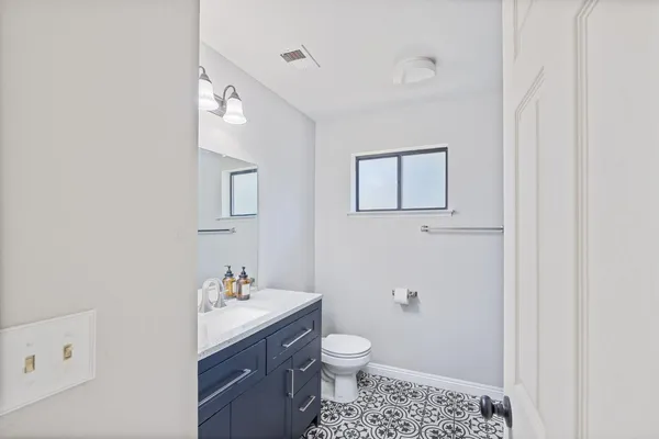 a bathroom with a toilet a sink and mirror