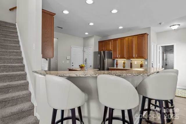 a kitchen with stainless steel appliances granite countertop a sink stove and refrigerator