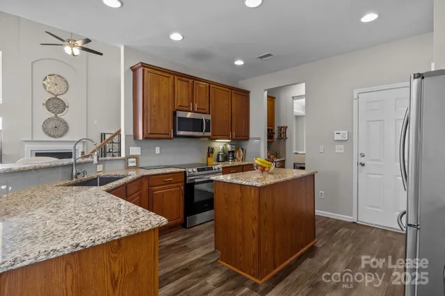 a kitchen with stainless steel appliances granite countertop a sink stove and microwave