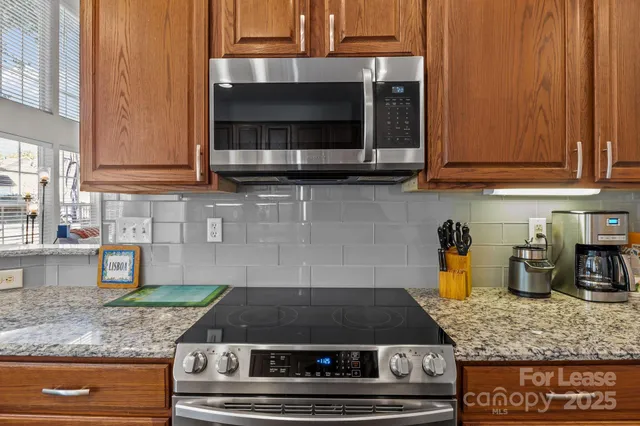 a kitchen with stainless steel appliances granite countertop a lot of cabinets