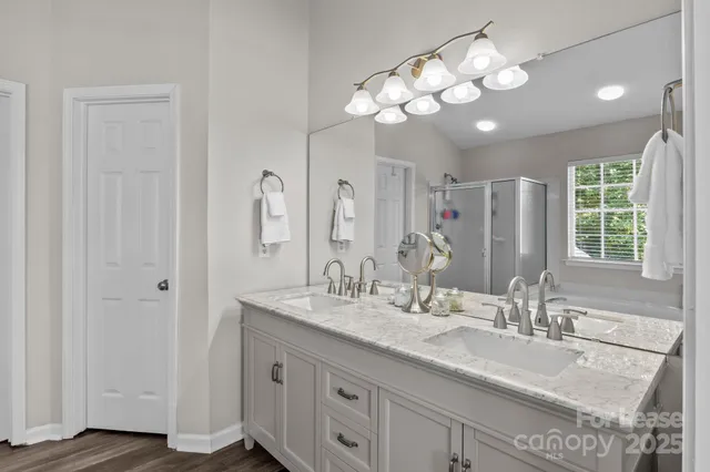 a bathroom with a granite countertop sink a mirror and a shower