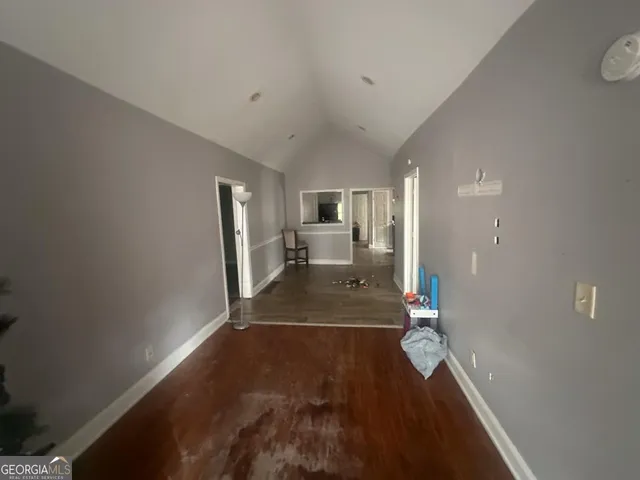 a view of a hallway with wooden floor and a living room