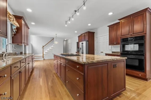 a kitchen with stainless steel appliances kitchen island granite countertop a stove and a refrigerator