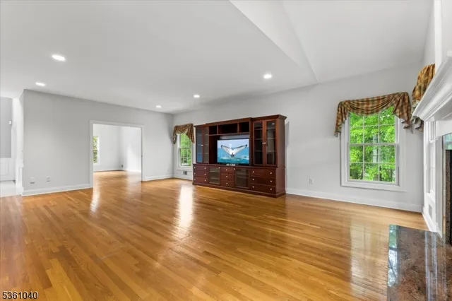 a living room with fireplace furniture flat screen tv and wooden floor