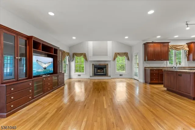 a view of empty room with wooden floor and fireplace