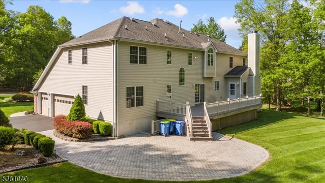 a view of a house with a big yard and large trees