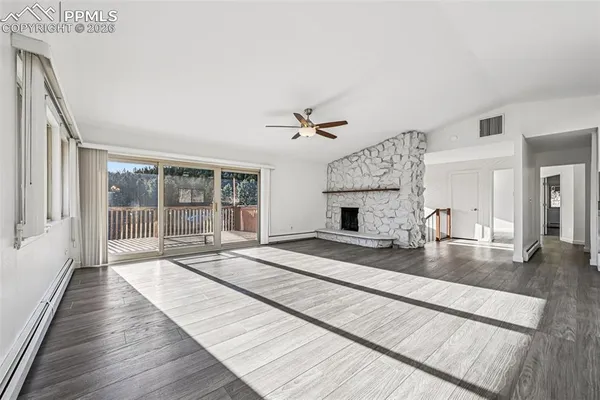 a view of a livingroom with a fireplace a chandelier and wooden floor