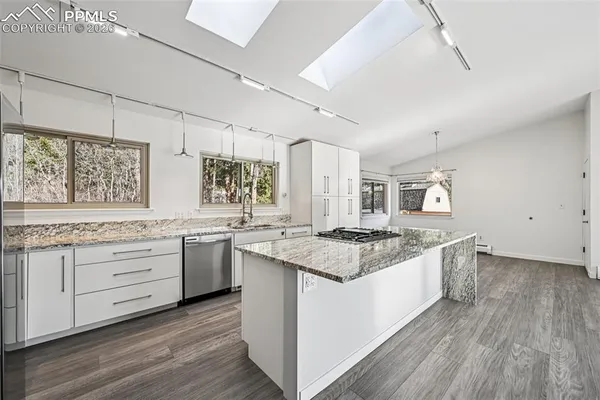 a kitchen with granite countertop white cabinets and white appliances