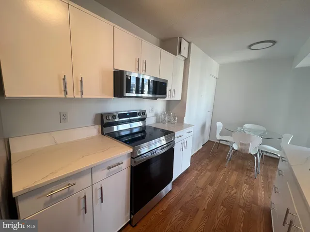 a kitchen with a sink a stove and white cabinets