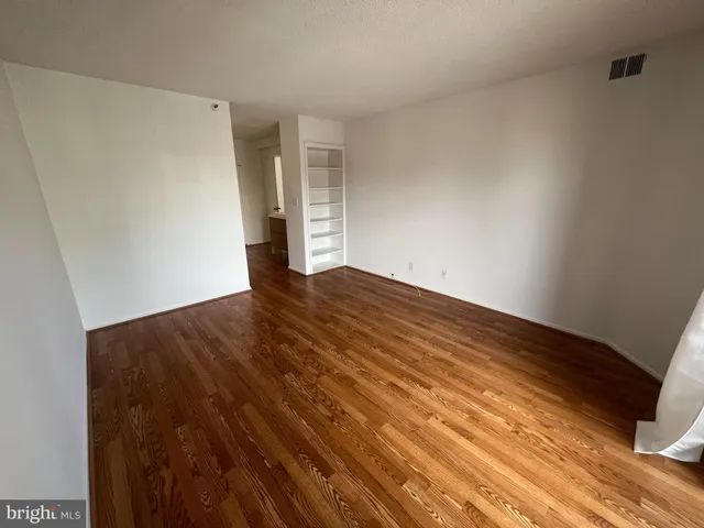 a view of empty room with wooden floor