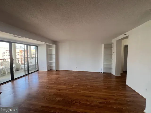 a view of an empty room with glass door and balcony