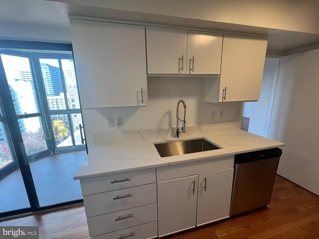 a kitchen with white cabinets a sink a window and appliances
