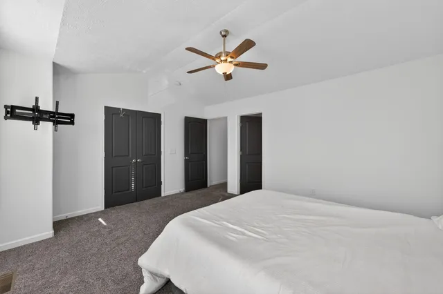 a bedroom with a bed and a ceiling fan