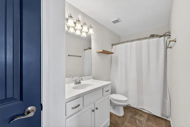 a bathroom with a toilet a sink and a mirror