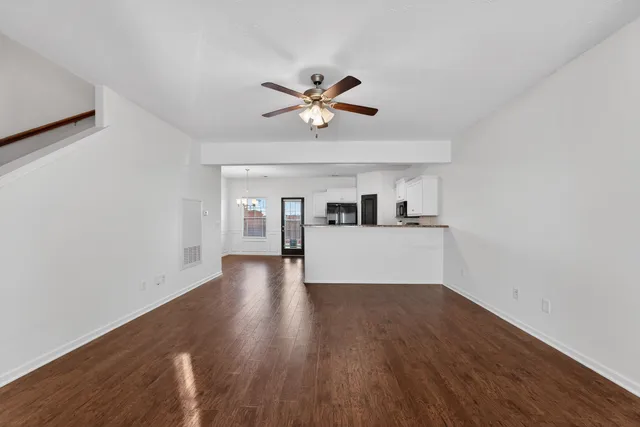 a view of a kitchen with wooden floor and a ceiling fan