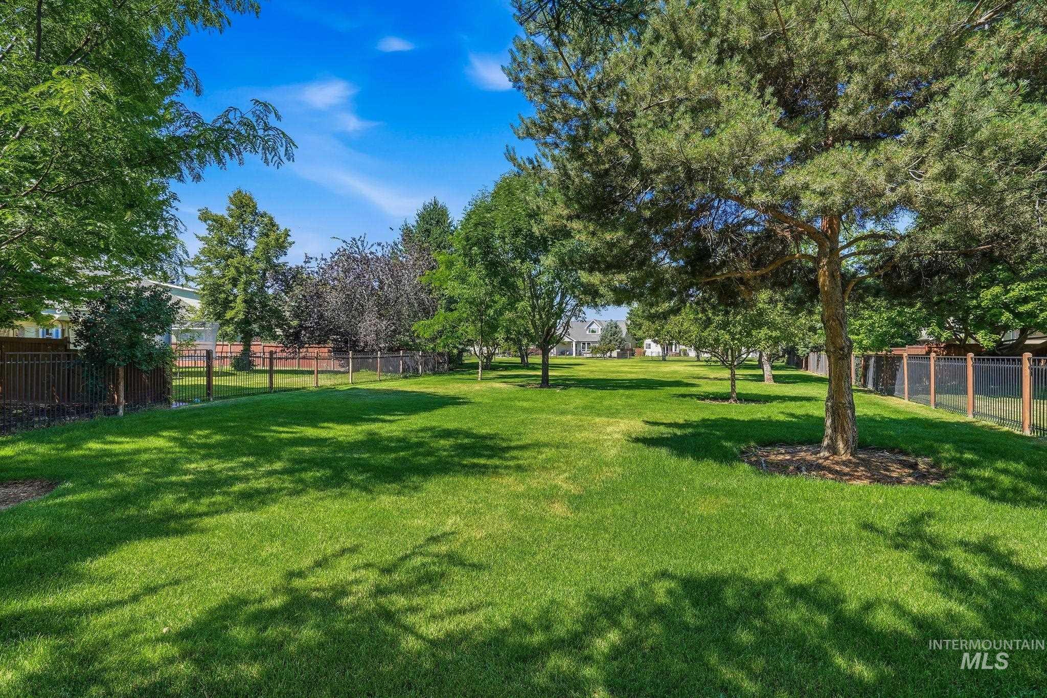 3969 North Hollymount Way Meridian, ID 83646 - Photo 45 of 47 Expansive green space featuring mature trees, partial fencing, and a manicured lawn