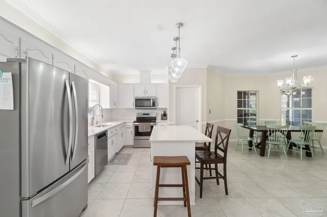 a kitchen with refrigerator and chairs