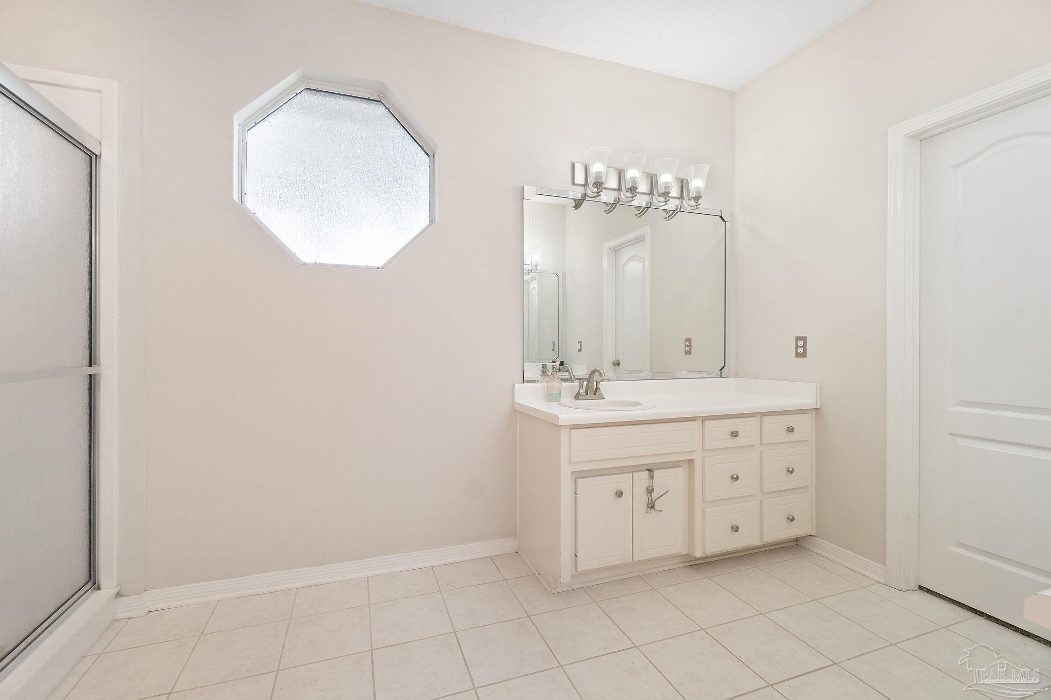 1504 Muirfield Road Cantonment, FL 32533 - Photo 22 of 35 a bathroom with a sink vanity and a mirror