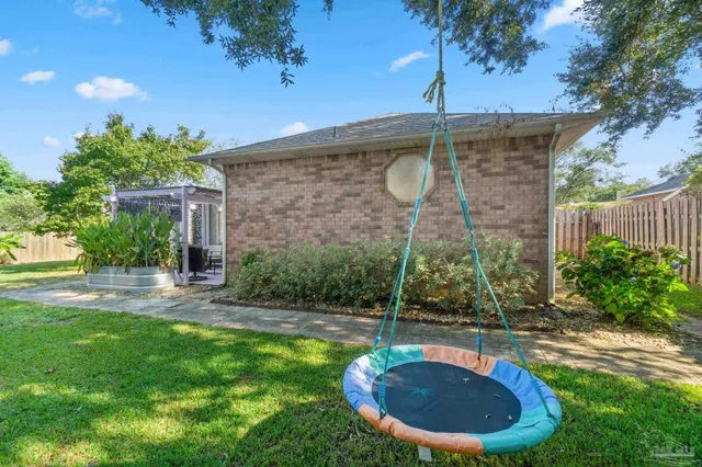 a view of a backyard with a fountain plants and large tree