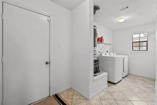 a bed sitting in a bedroom next to a window and a chandelier