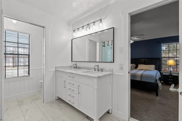 a bathroom with a granite countertop shower sink and mirror