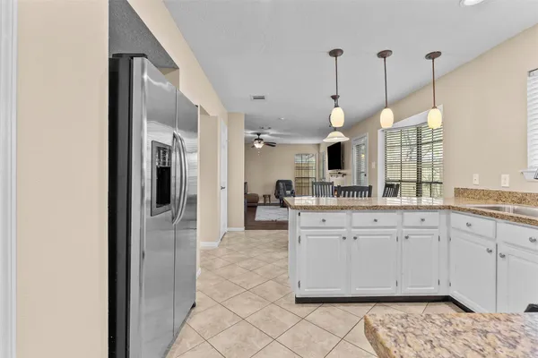 a open kitchen with granite countertop a sink a stove and chairs