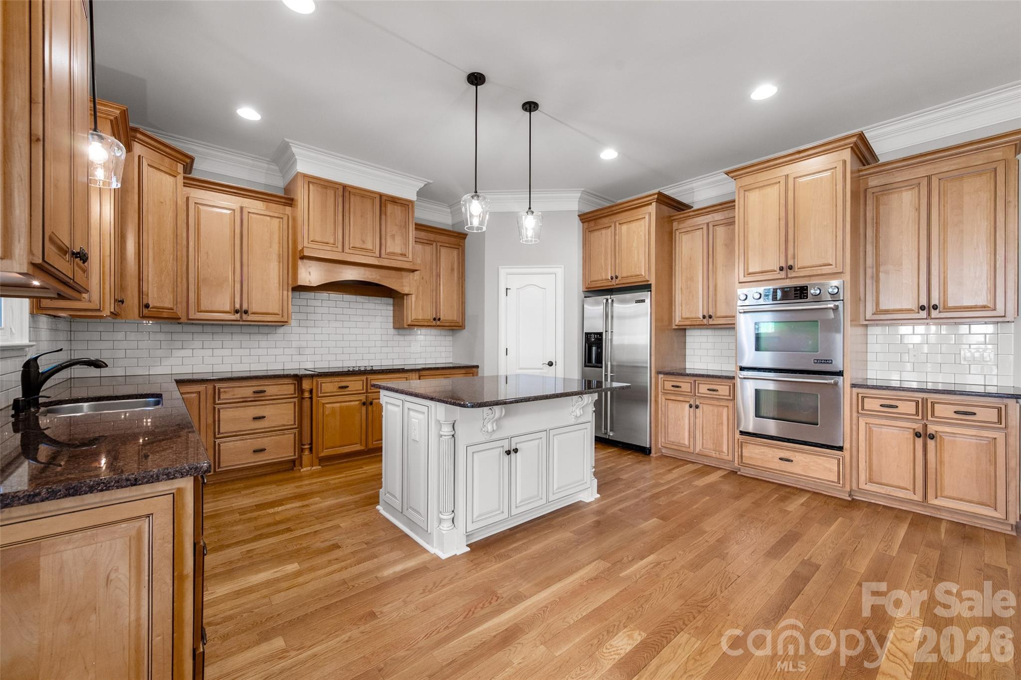 406 Belo Court Fort Mill, SC 29715 - Photo 21 of 46 a kitchen with stainless steel appliances granite countertop a sink a stove and a wooden floors