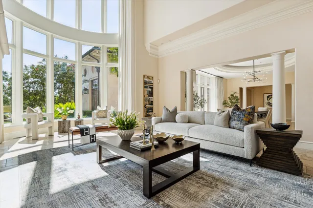 a living room with furniture a fireplace and a large window