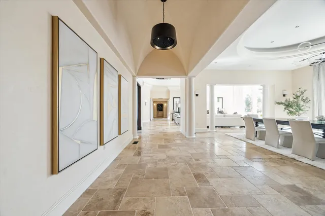a view of a hallway to a livingroom with furniture and windows