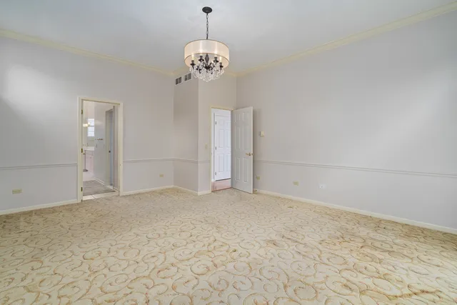 a view of an empty room with a chandelier fan