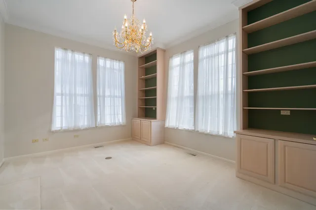 a view of an empty room with a window and a kitchen