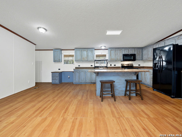 135 Savannah Ridge Von Ormy, TX 78073 - Photo 31 of 45 a kitchen with stainless steel appliances a refrigerator a stove top oven and a center island