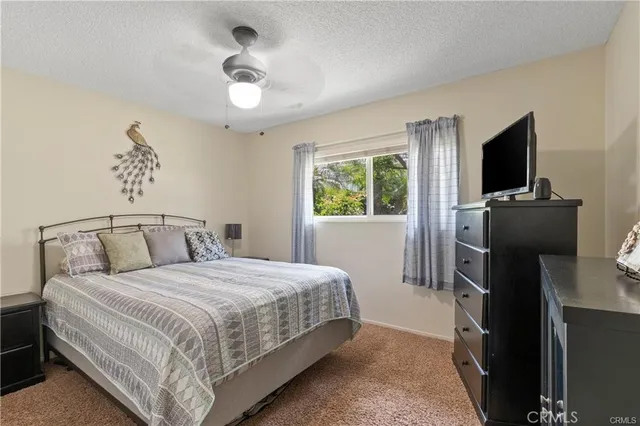 a bedroom with a bed and a flat tv screen on the dresser