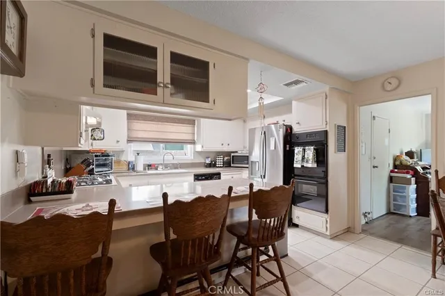 a kitchen with stainless steel appliances kitchen island granite countertop a table and chairs in it