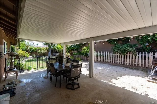 a view of a patio with a table chairs and a backyard