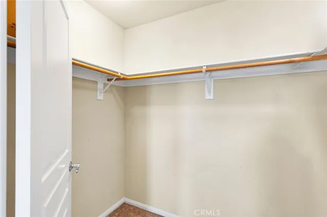 a bedroom with a large bed and a chandelier fan