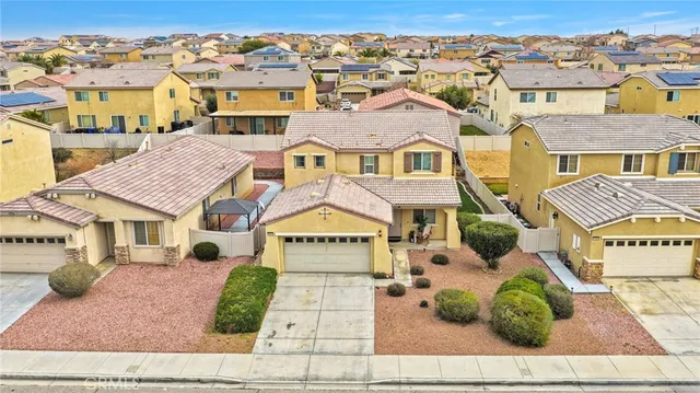 an aerial view of a city with lots of residential buildings ocean and mountain view in back