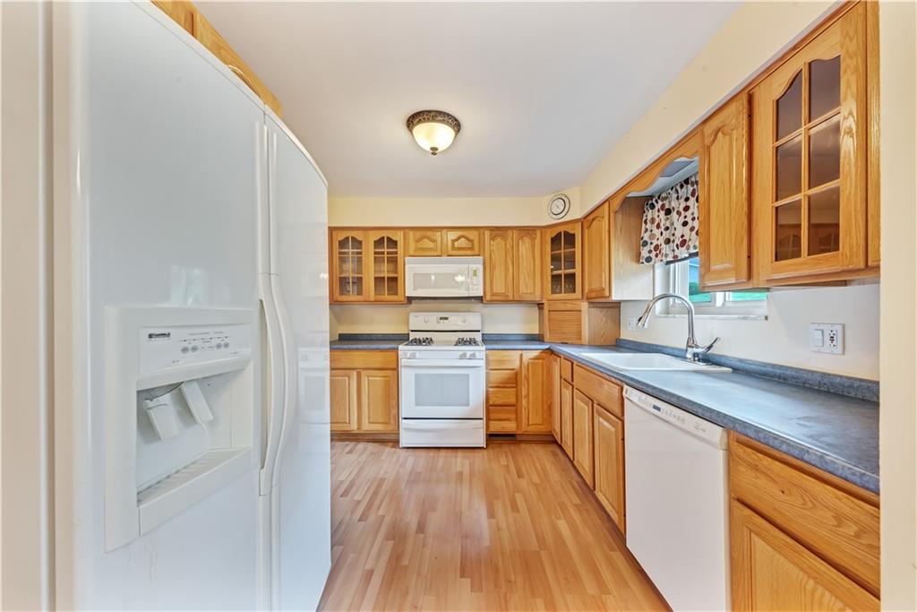 98 Grace Street McKees Rocks, PA 15136 - Photo 5 of 15 a kitchen with stainless steel appliances granite countertop a sink and wooden cabinets with a large window