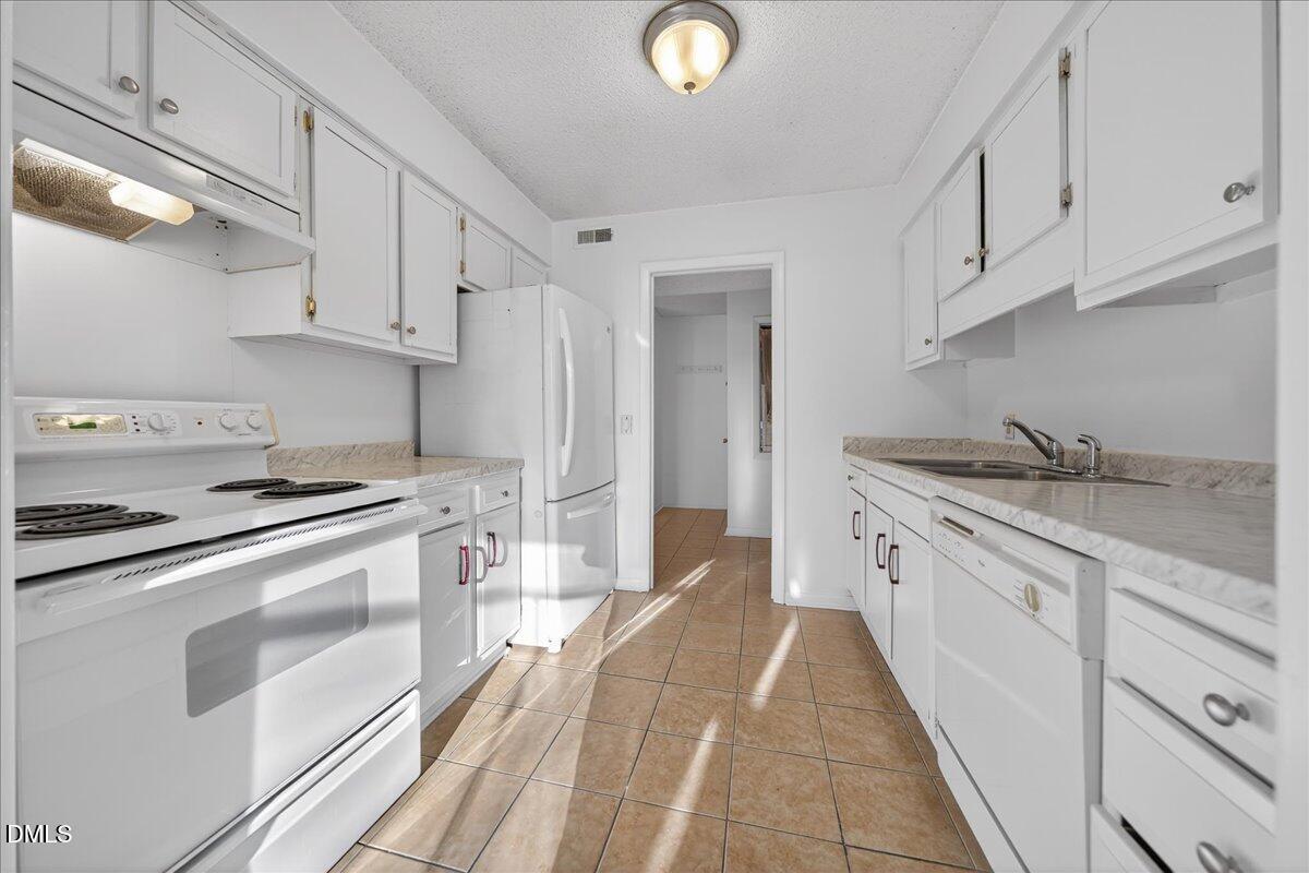 3088 Colony Road, Unit 3088D Durham, NC 27705 - Photo 8 of 25 a kitchen with cabinets appliances and a sink