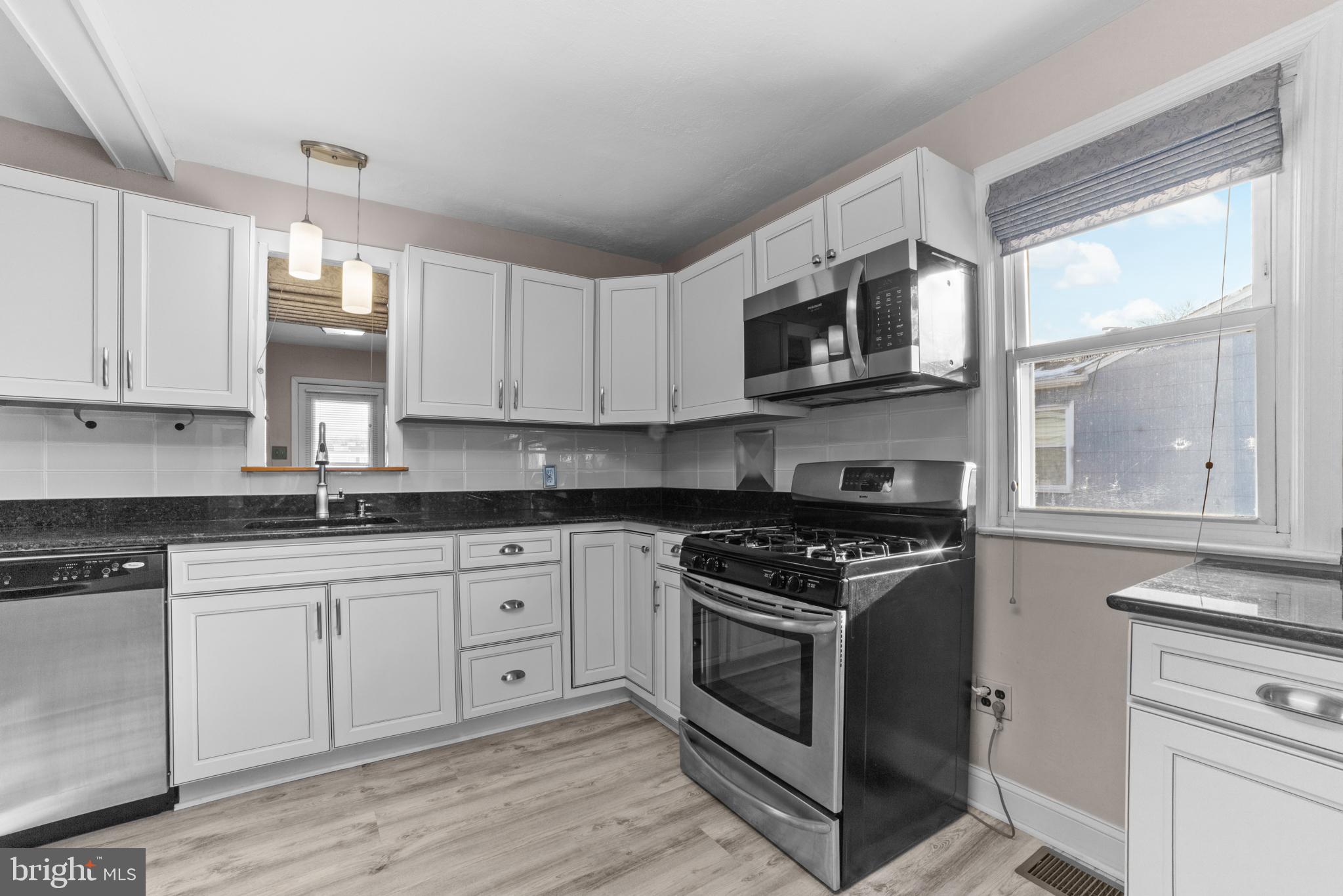 319 South Coles Avenue Maple Shade, NJ 08052 - Photo 8 of 23 a kitchen with stainless steel appliances granite countertop white cabinets a sink a stove a microwave and island