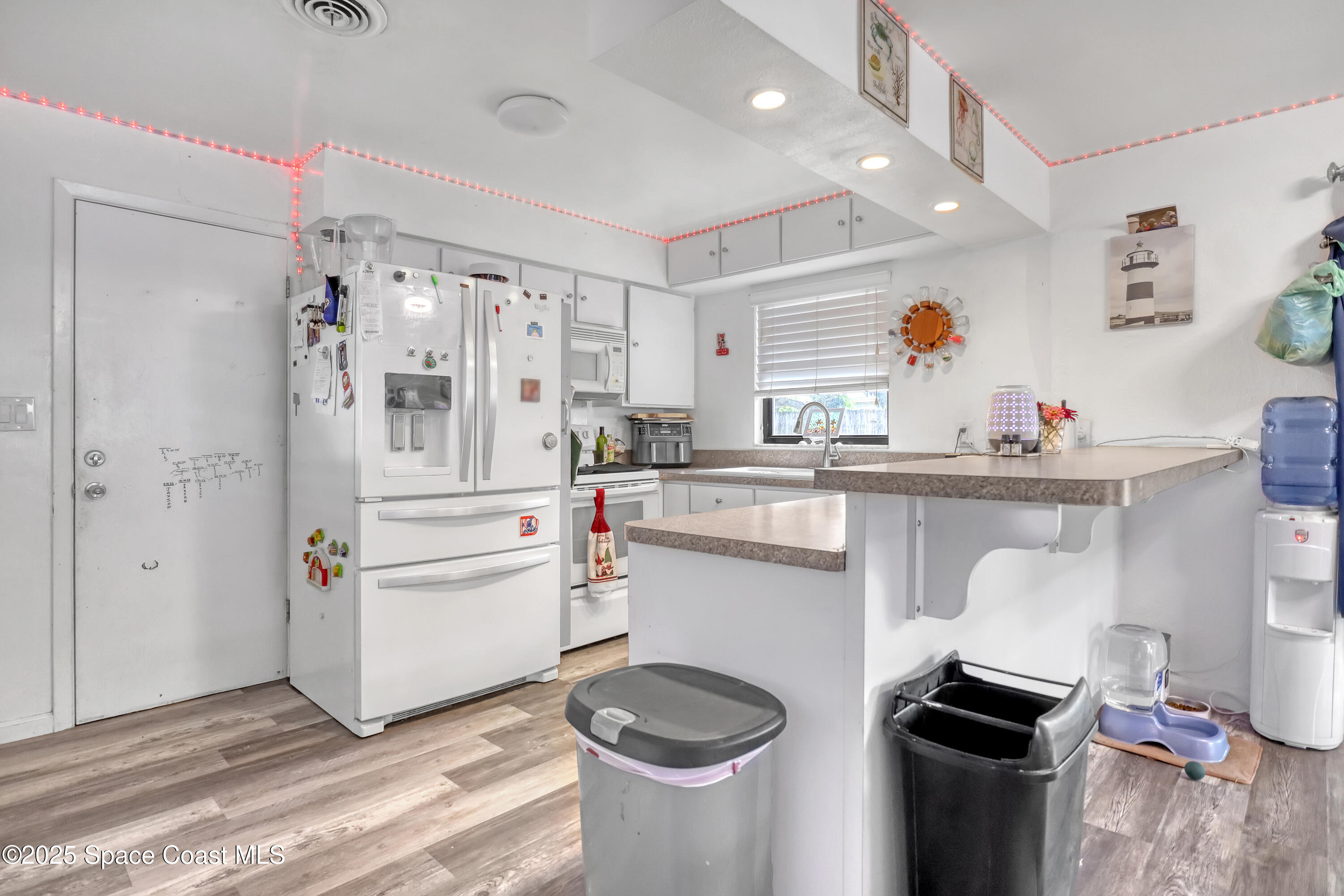355 Aztec Avenue Merritt Island, FL 32952 - Photo 12 of 48 a kitchen with white cabinets and appliances