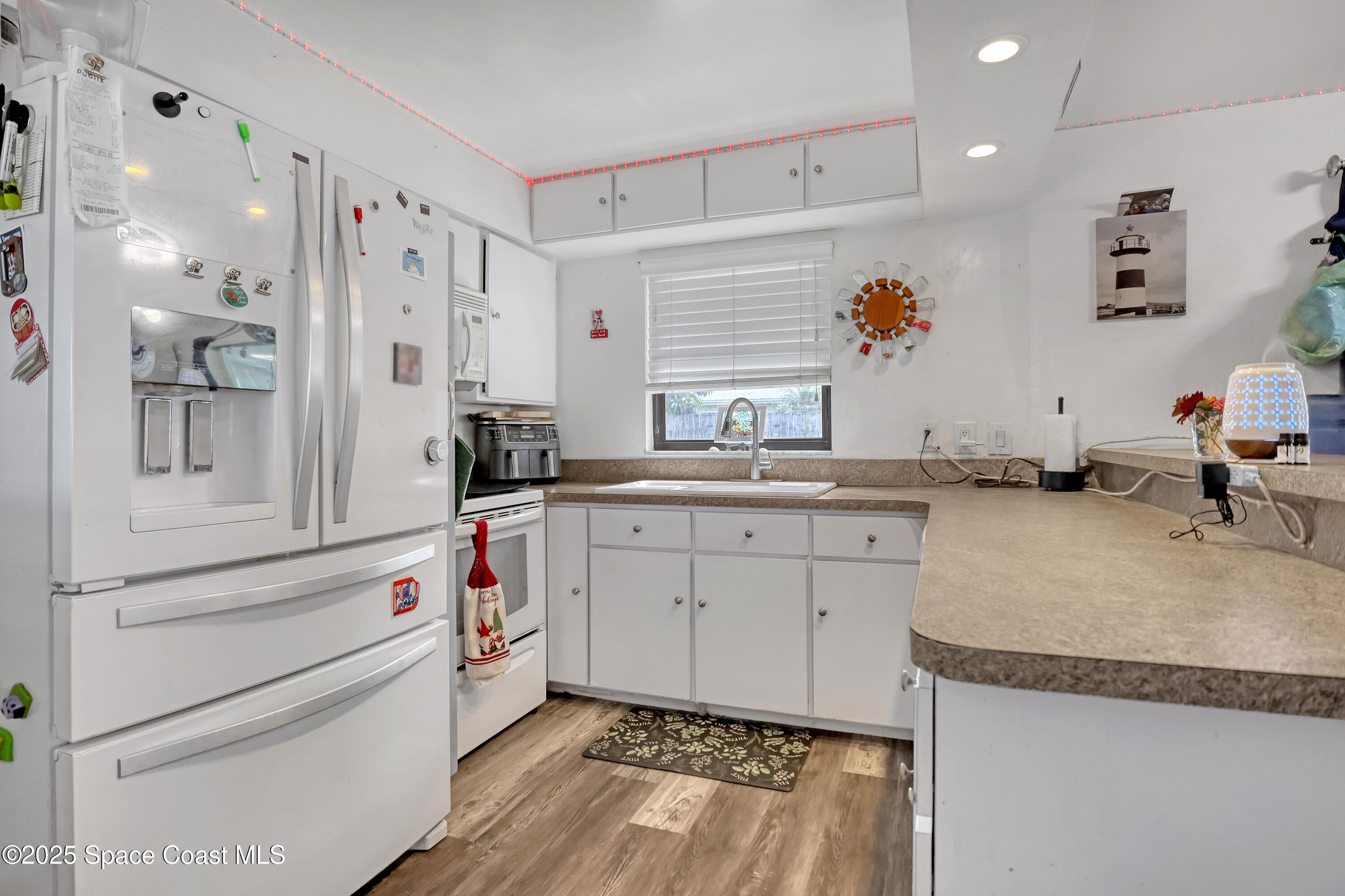 355 Aztec Avenue Merritt Island, FL 32952 - Photo 13 of 48 a kitchen with white cabinets and sink
