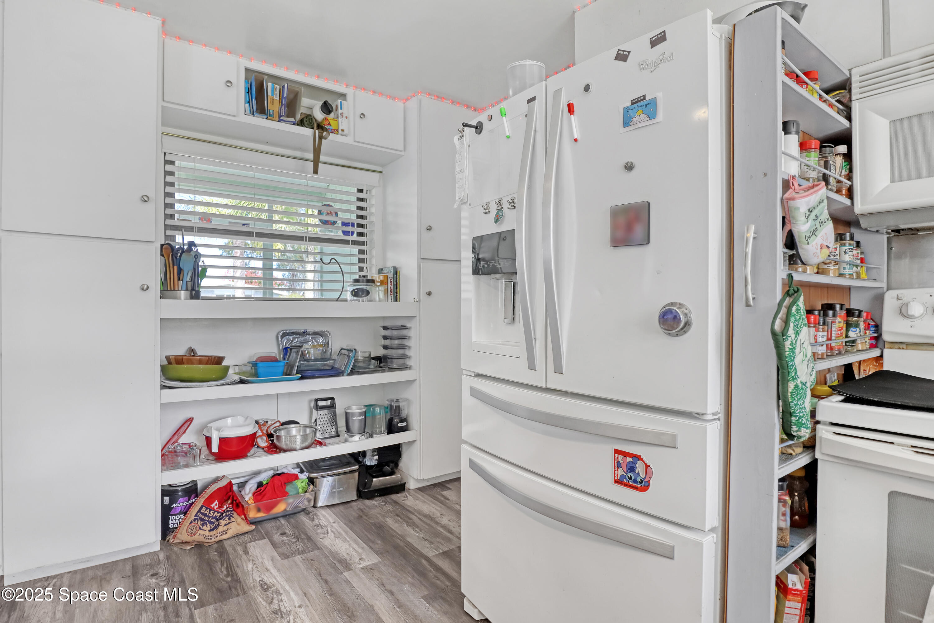355 Aztec Avenue Merritt Island, FL 32952 - Photo 16 of 48 a utility room with fridge dryer and baby crib