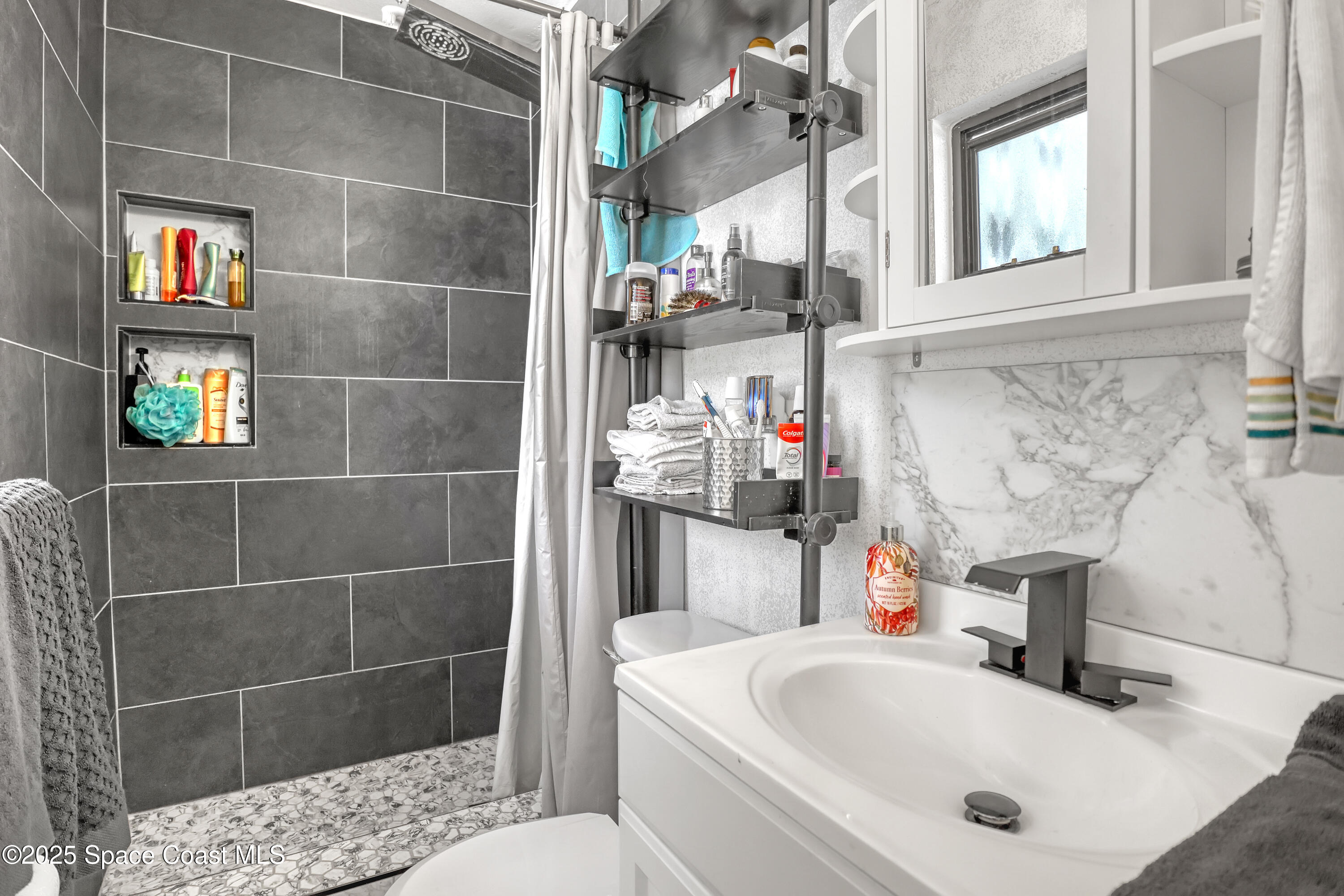 355 Aztec Avenue Merritt Island, FL 32952 - Photo 19 of 48 a bathroom with a sink toilet and shower