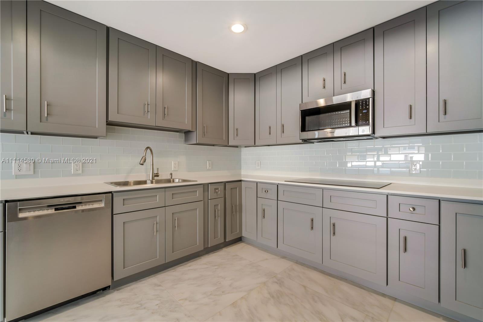 825 Southwest 28th Road Miami, FL 33129 - Photo 14 of 40 a kitchen with cabinets appliances a sink and a counter top space