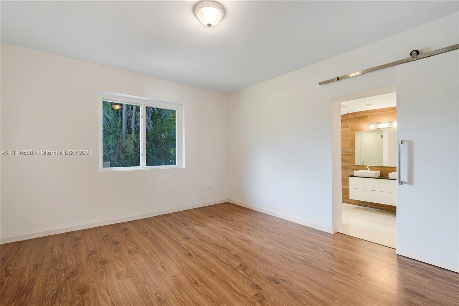 825 Southwest 28th Road Miami, FL 33129 - Photo 17 of 40 an empty room with wooden floor and windows