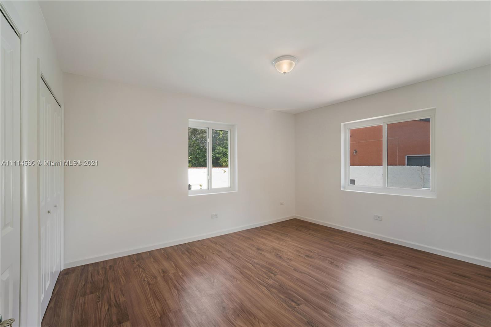 825 Southwest 28th Road Miami, FL 33129 - Photo 21 of 40 an empty room with wooden floor and windows