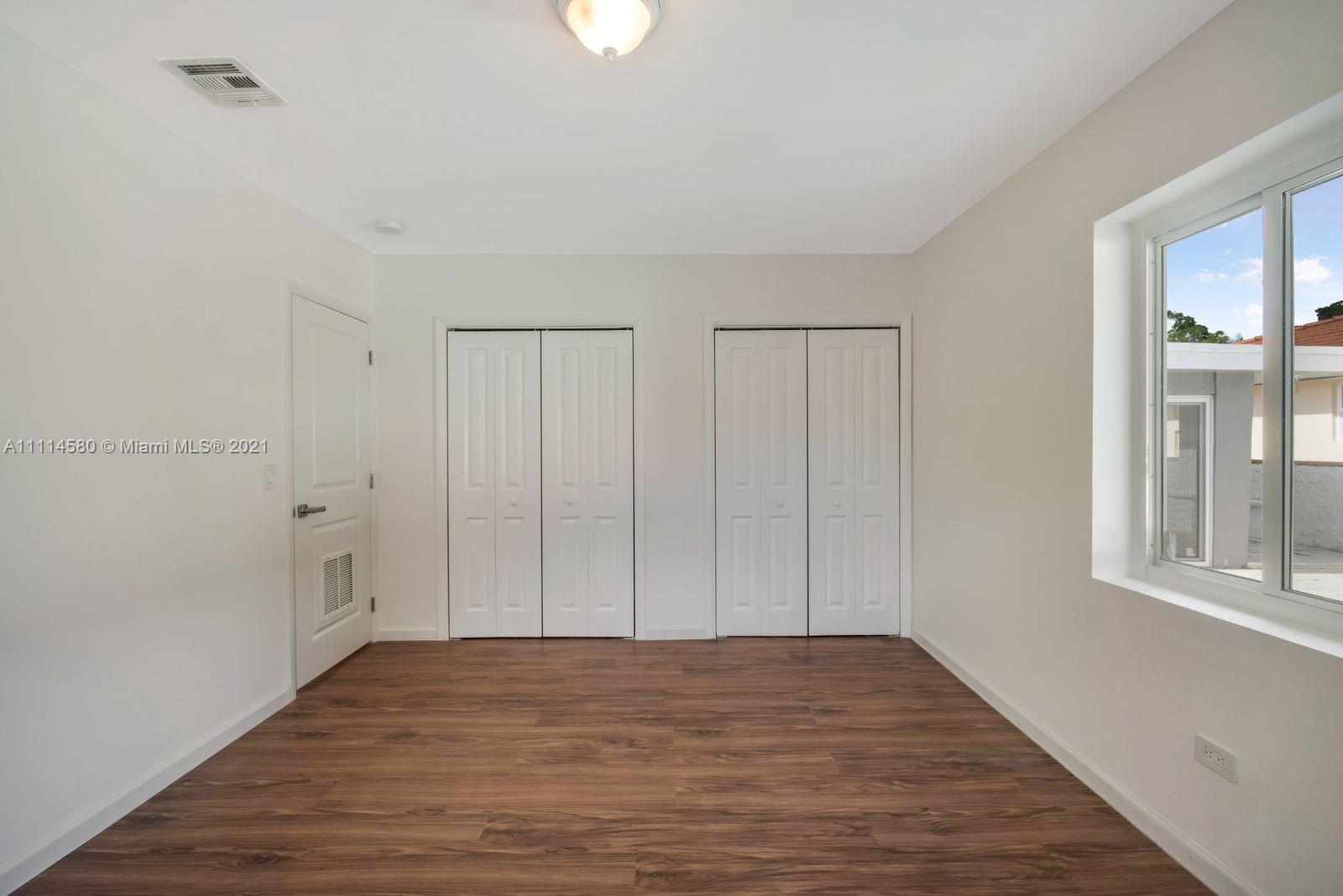 825 Southwest 28th Road Miami, FL 33129 - Photo 22 of 40 a view of an empty room with wooden floor and a window