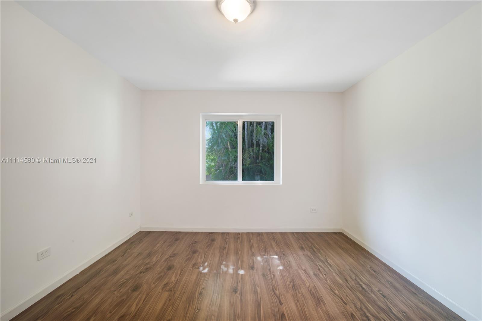 825 Southwest 28th Road Miami, FL 33129 - Photo 24 of 40 a view of an empty room with wooden floor and a window