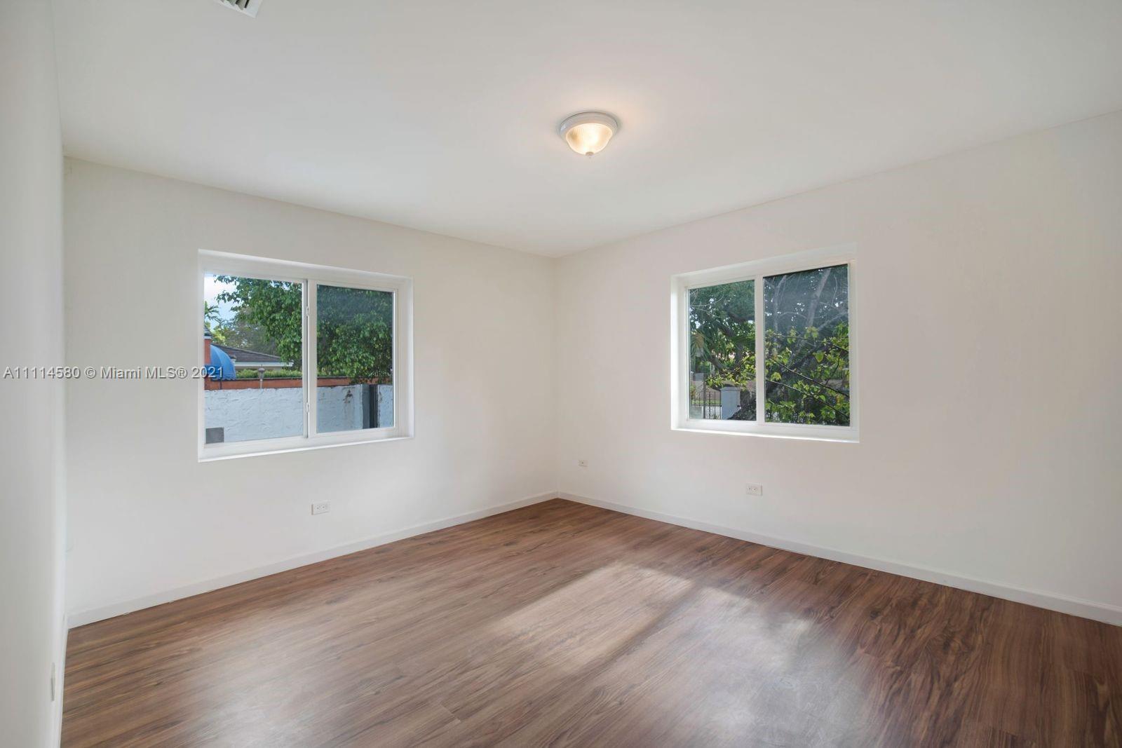 825 Southwest 28th Road Miami, FL 33129 - Photo 26 of 40 an empty room with wooden floor and windows